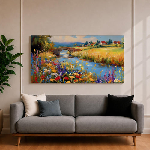 Panoramic landscape painting of a winding river flowing through a countryside meadow filled with colorful wildflowers. A small stone bridge arches over the water while fields, cottages, and rolling hills stretch into the distance under a bright sky, rendered with vibrant textured brushstrokes.