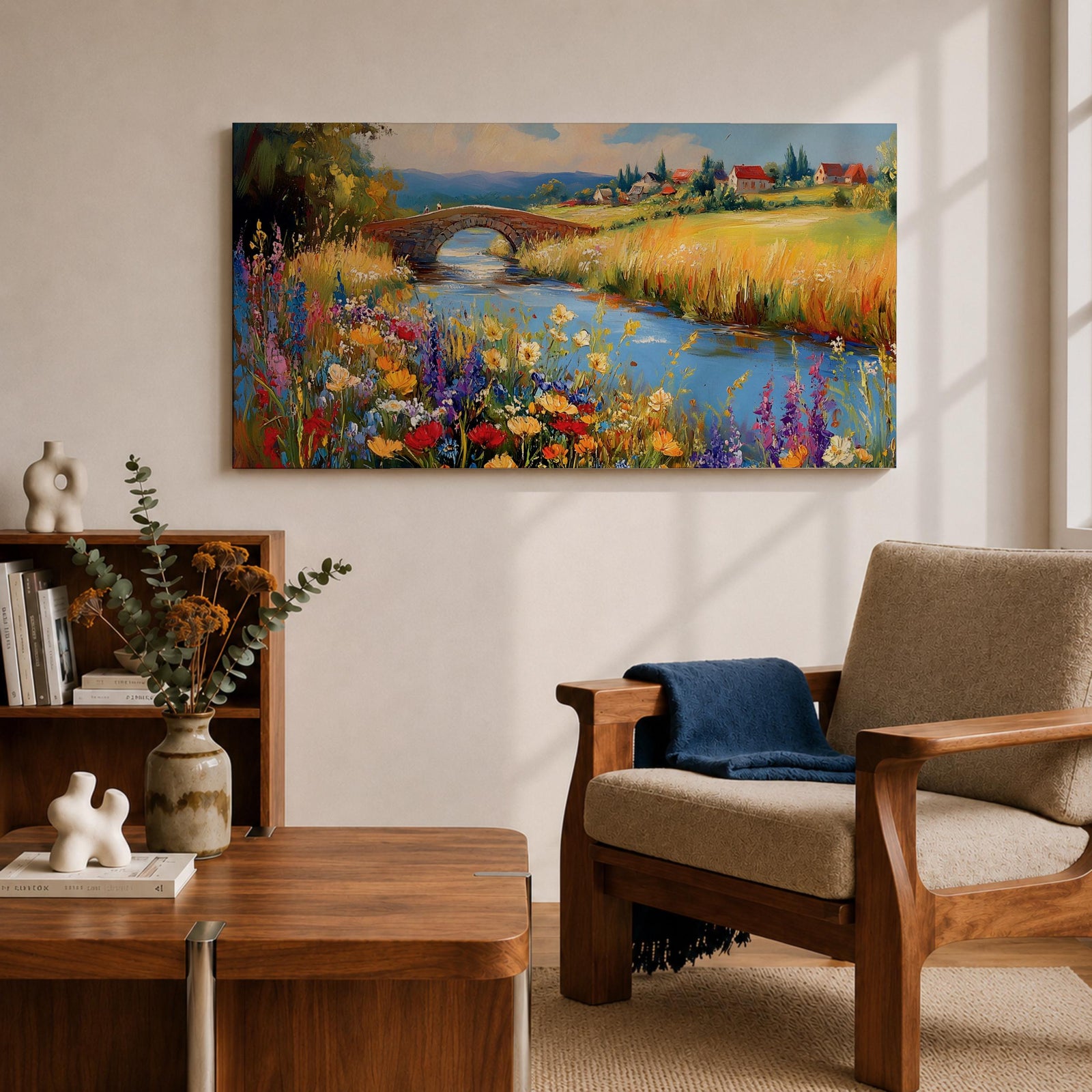 Panoramic landscape painting of a winding river flowing through a countryside meadow filled with colorful wildflowers. A small stone bridge arches over the water while fields, cottages, and rolling hills stretch into the distance under a bright sky, rendered with vibrant textured brushstrokes.