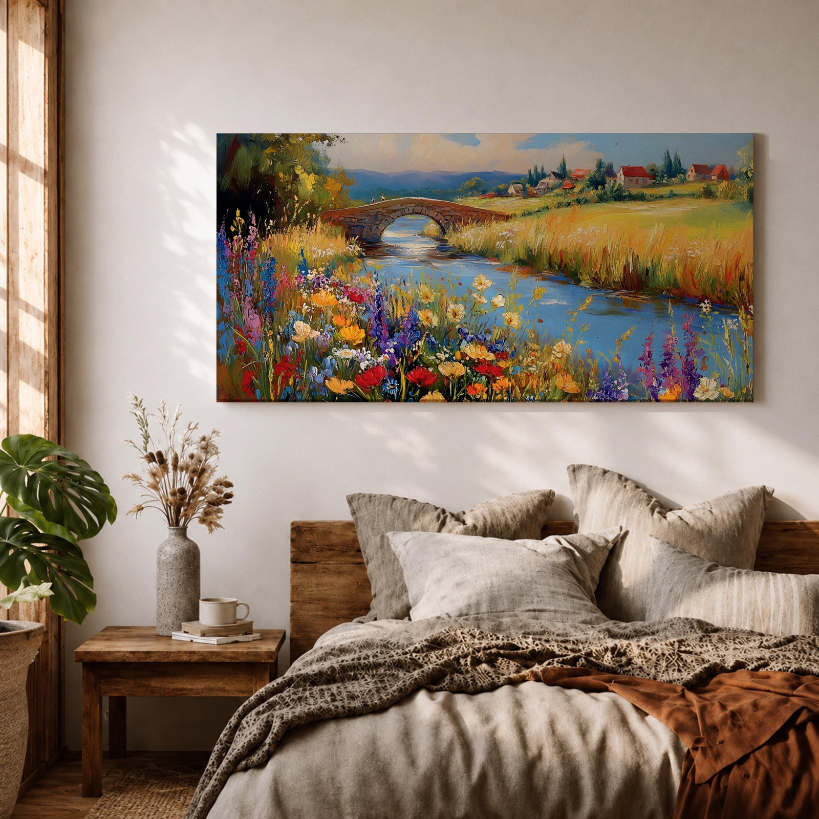 Panoramic landscape painting of a winding river flowing through a countryside meadow filled with colorful wildflowers. A small stone bridge arches over the water while fields, cottages, and rolling hills stretch into the distance under a bright sky, rendered with vibrant textured brushstrokes.