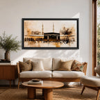 Panoramic painting of the Kaaba at Masjid al Haram in Mecca surrounded by mosque arches and tall minarets. The composition features the black cube structure at the center with pilgrims gathered in the courtyard, rendered in expressive brushstrokes with beige, brown, and gold tones.
