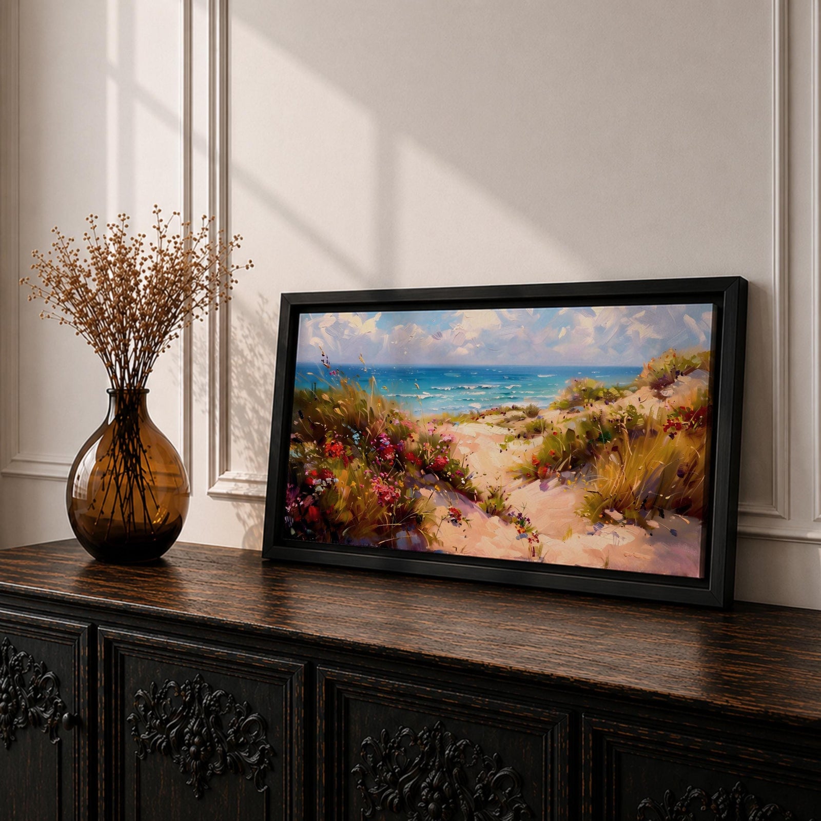 Panoramic coastal landscape painting of sandy beach dunes leading toward turquoise ocean waves under a bright sky. Tall grasses and colorful wildflowers line a winding path through the dunes, painted with loose textured brushstrokes capturing sunlight, sea breeze, and shoreline scenery.