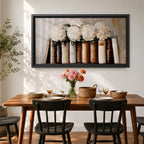 Panoramic still life painting of white hydrangea flowers arranged inside stacked vintage books with neutral beige and cream tones in a soft textured background.