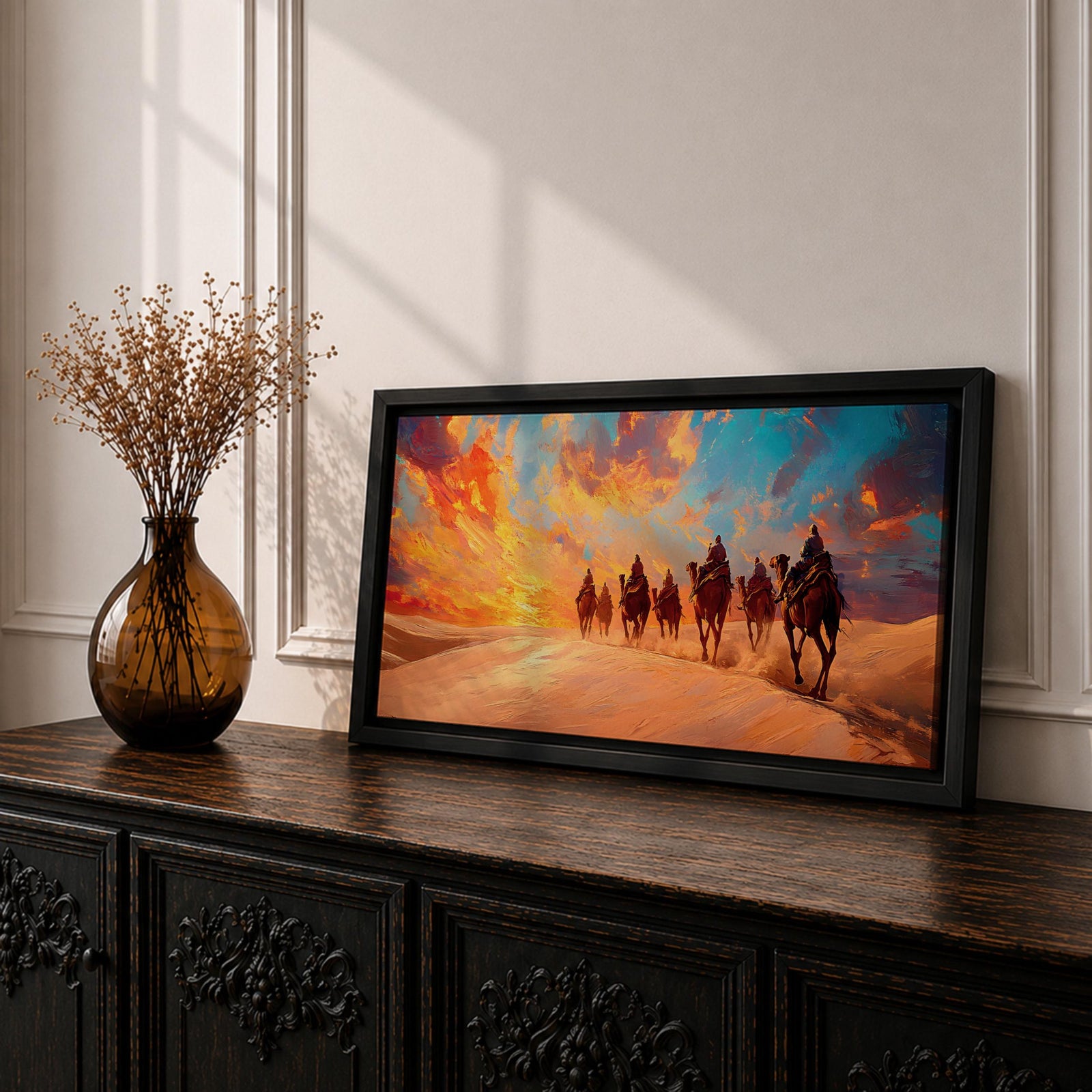 Panoramic painting of a camel caravan traveling across golden desert dunes at sunset with riders silhouetted beneath a vibrant dramatic sky.