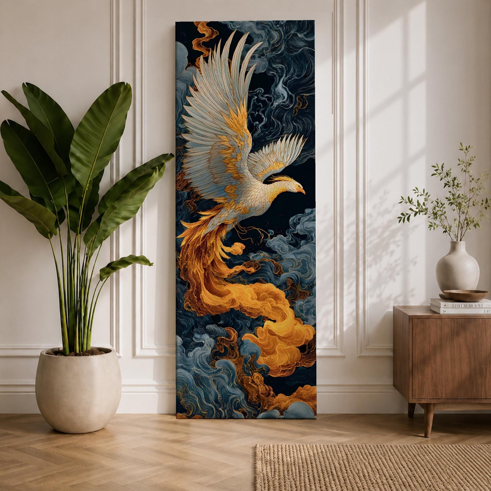 A tall vertical artwork depicts a majestic phoenix with outstretched wings rendered in intricate feather detail, its white and gold plumage glowing against swirling dark blue and smoky cloud forms, while flowing golden flames trail from its body, blending Asian-inspired brushwork with dynamic movement and a mythic, firebird presence.