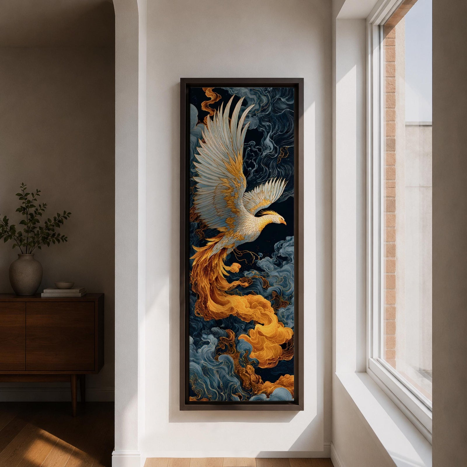 A tall vertical artwork depicts a majestic phoenix with outstretched wings rendered in intricate feather detail, its white and gold plumage glowing against swirling dark blue and smoky cloud forms, while flowing golden flames trail from its body, blending Asian-inspired brushwork with dynamic movement and a mythic, firebird presence.