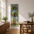A tall narrow painting of two palm trees with slender trunks and lush green fronds, rendered in expressive brushstrokes with layered tones of green, gold, and soft red against a muted abstract background of blue and gray, creating a loose impressionistic tropical landscape composition.