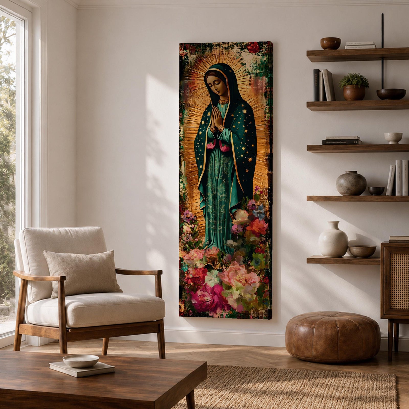 A tall narrow vertical painting of the Virgin Mary Guadalupe shown in prayer with hands clasped, wearing a deep teal mantle adorned with gold stars and a soft pink dress, surrounded by radiant golden rays, with rich floral elements in vibrant pink, red, and cream tones at the base, rendered in a textured painterly style with warm, aged tones.