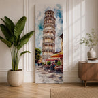 Long vertical watercolor style painting of the Leaning Tower rising above a lively Italian piazza with outdoor café tables and people walking along a stone street. The famous marble tower tilts gently against a bright sky while expressive brushstrokes capture the atmosphere of a historic Italian landmark and travel scene.