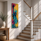 A tall narrow artwork of the Statue of Liberty shown from a low angle with the torch raised, rendered in bold pop art style with vibrant teal tones contrasted by bright pink and yellow paint splashes, featuring dynamic splatter textures and graphic shading in a modern abstract urban composition.