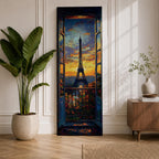 Long vertical painting of the Eiffel Tower seen through an open window with balcony railings and flowers in the foreground. A dramatic sunset sky glows with orange and blue tones above the Paris skyline while expressive brushstrokes create a romantic cityscape composition.