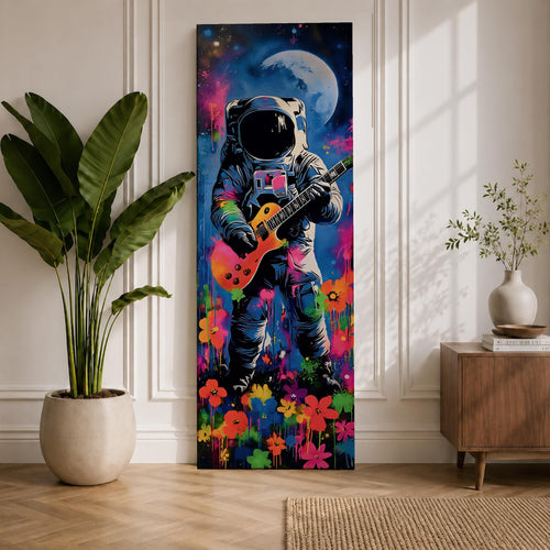 A tall vertical artwork shows an astronaut in a detailed space suit playing an electric guitar, set against a vivid cosmic backdrop with a glowing moon, deep blue sky, and splashes of neon pink, green, and orange paint, while bright flowers bloom at the base, blending surreal space imagery with street art style and bold expressive color.