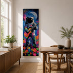 A tall vertical artwork shows an astronaut in a detailed space suit playing an electric guitar, set against a vivid cosmic backdrop with a glowing moon, deep blue sky, and splashes of neon pink, green, and orange paint, while bright flowers bloom at the base, blending surreal space imagery with street art style and bold expressive color.