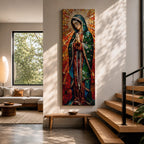 Long vertical stained glass style depiction of Our Lady of Guadalupe with hands clasped in prayer. She wears a green mantle decorated with stars and a red robe while radiant golden rays form a halo behind her, composed of colorful mosaic glass pieces forming a luminous devotional image.