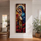 Long vertical stained glass style depiction of the Virgin Mary with hands clasped in prayer. She wears a blue mantle and cream robe while a circular halo glows behind her head and red roses bloom at her feet, all formed with colorful glass segments in a luminous devotional composition.