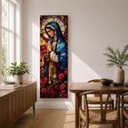 Long vertical stained glass style depiction of the Virgin Mary with hands clasped in prayer. She wears a blue mantle and cream robe while a circular halo glows behind her head and red roses bloom at her feet, all formed with colorful glass segments in a luminous devotional composition.