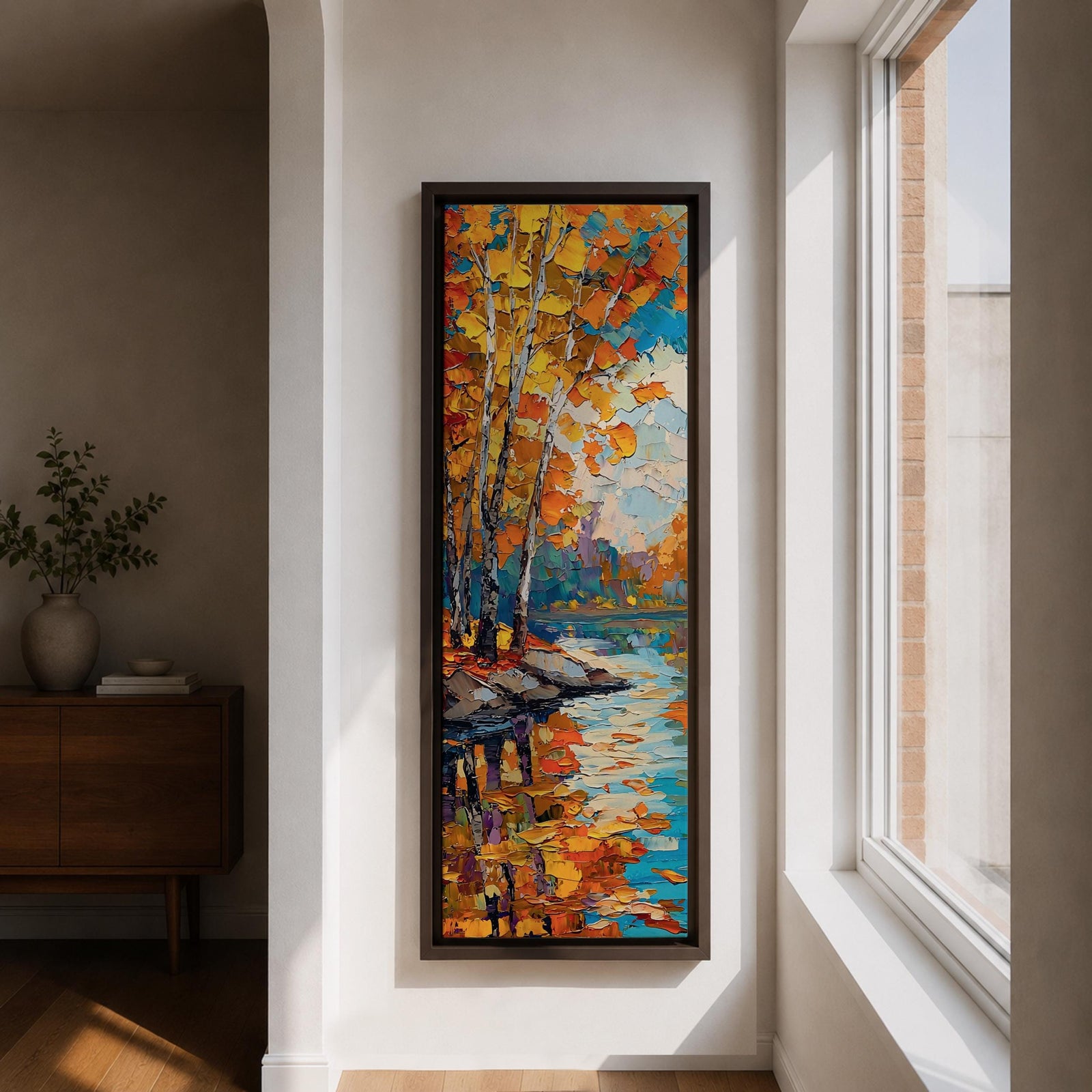 Tall vertical landscape painting of slender birch trees with golden autumn leaves along a calm reflective river. Thick palette knife oil brushstrokes create vibrant fall colors of orange, yellow, and blue with the trees mirrored in the water while distant forest and sky appear softly textured in the background.