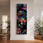 Tall vertical botanical artwork featuring glowing neon flowers in vibrant rainbow colors against a deep black background. Large luminous blossoms in pink, orange, purple, and blue are surrounded by detailed leaves, creating a modern floral composition with bold contrast and iridescent color transitions.
