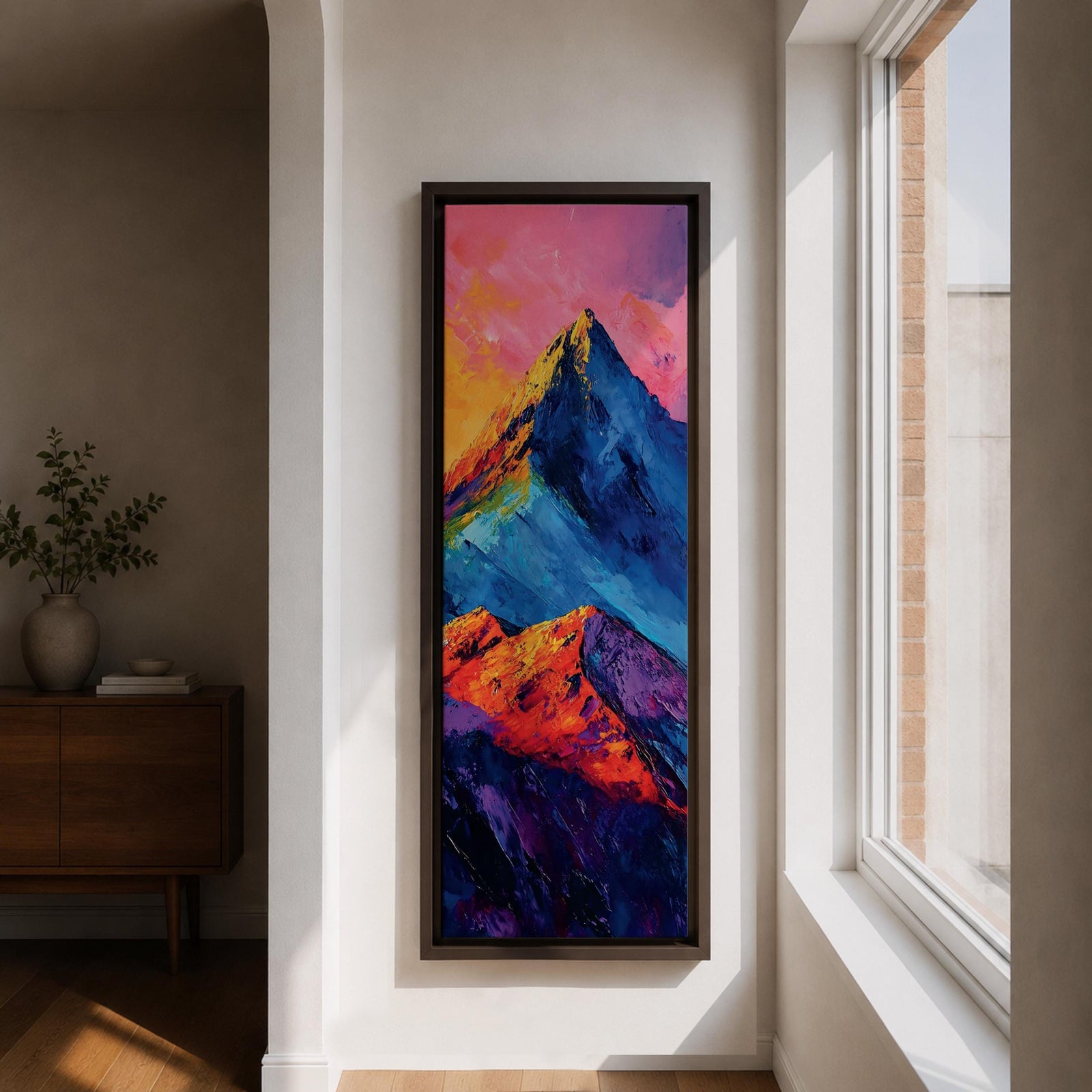 Tall vertical abstract mountain painting with bold colorful peaks in vibrant blue, red, purple, and yellow tones. Thick impasto brushstrokes create dramatic alpine ridges beneath a bright pink and orange sky, forming a modern expressive mountain landscape.