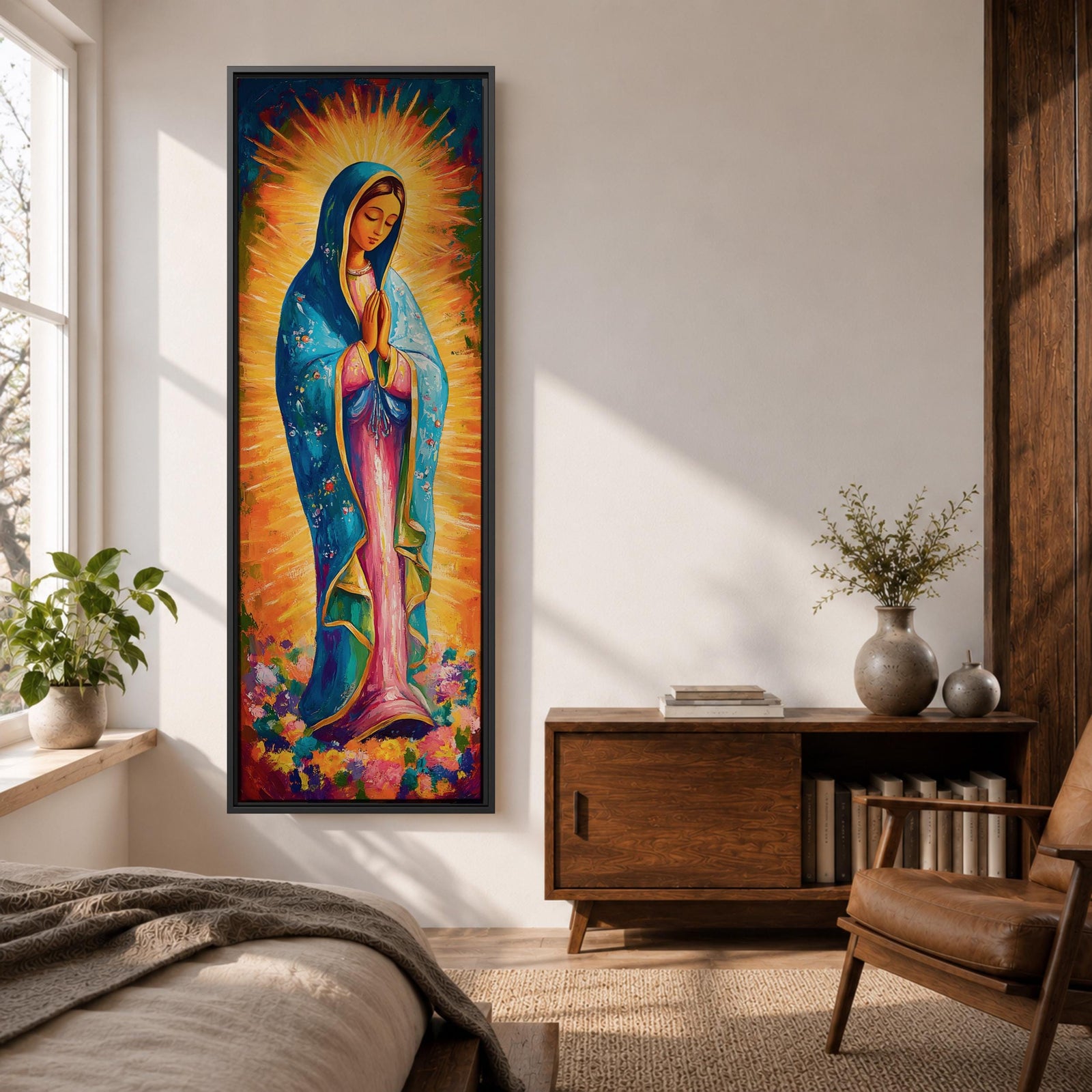 Long vertical painting of the Virgin Mary standing in prayer with hands together, wearing a blue mantle over a pink robe and surrounded by radiant golden rays. Colorful flowers gather at her feet while expressive brushstrokes and vibrant tones create a devotional depiction inspired by the Virgen de Guadalupe iconography.