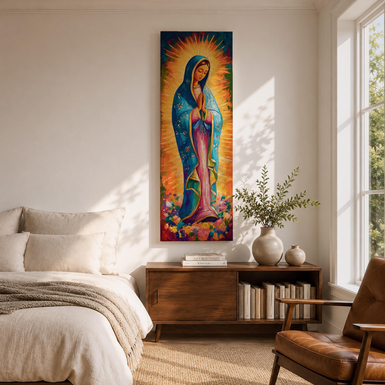 Long vertical painting of the Virgin Mary standing in prayer with hands together, wearing a blue mantle over a pink robe and surrounded by radiant golden rays. Colorful flowers gather at her feet while expressive brushstrokes and vibrant tones create a devotional depiction inspired by the Virgen de Guadalupe iconography.