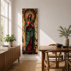 Long vertical painting of the Virgin Mary standing with hands clasped in prayer, wearing a deep red robe and teal mantle. An ornate circular golden halo with sacred symbols forms a radiant backdrop while textured brushwork and aged tones create a traditional Catholic devotional icon style composition.
