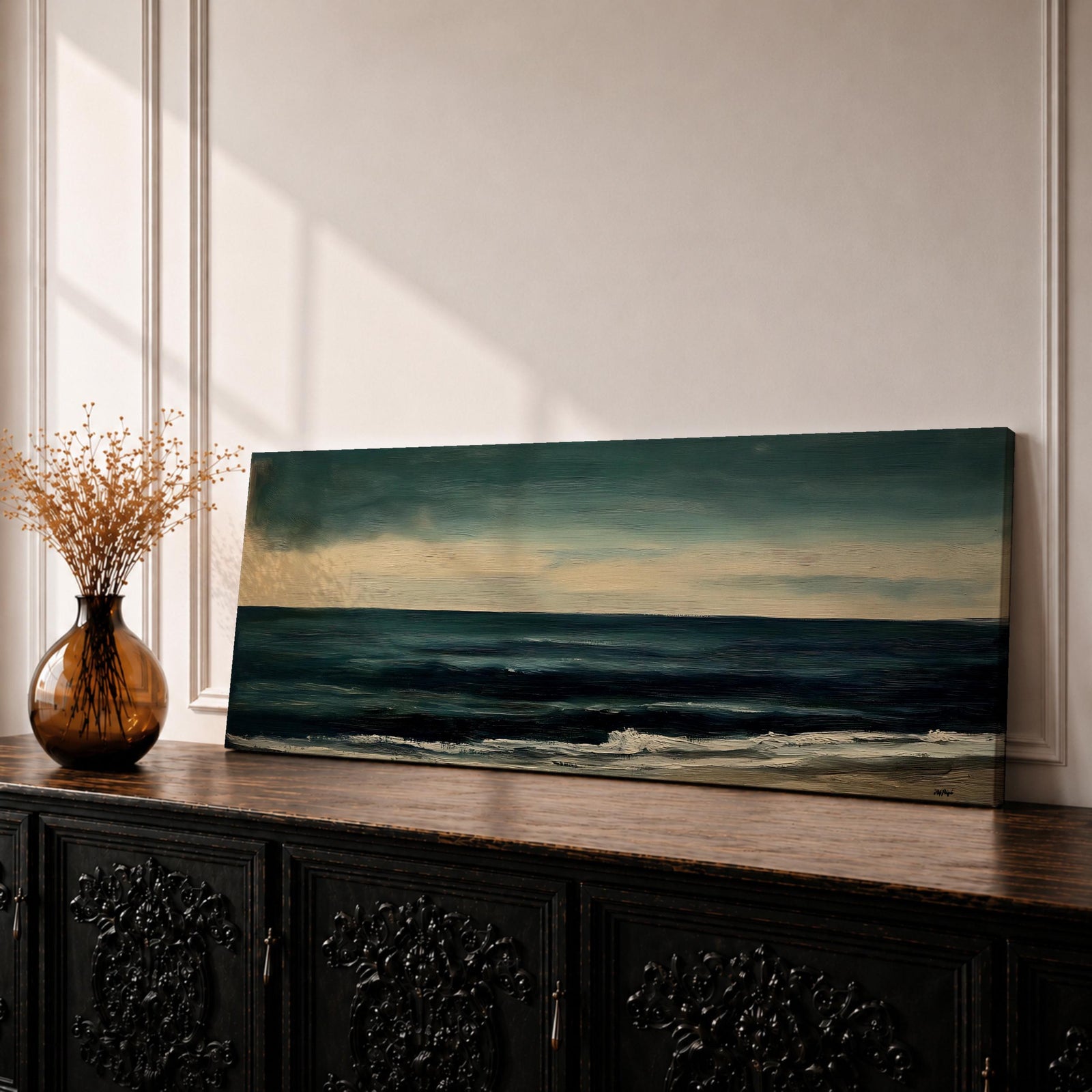 Panoramic seascape painting showing dark rolling waves beneath a dramatic cloudy sky with faint light breaking along the distant horizon. Deep teal and navy tones blend across the water while textured brushstrokes form soft foam along the shoreline, creating a moody minimalist coastal composition across the wide horizontal canvas.