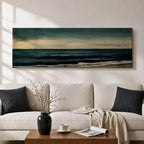 Panoramic seascape painting showing dark rolling waves beneath a dramatic cloudy sky with faint light breaking along the distant horizon. Deep teal and navy tones blend across the water while textured brushstrokes form soft foam along the shoreline, creating a moody minimalist coastal composition across the wide horizontal canvas.