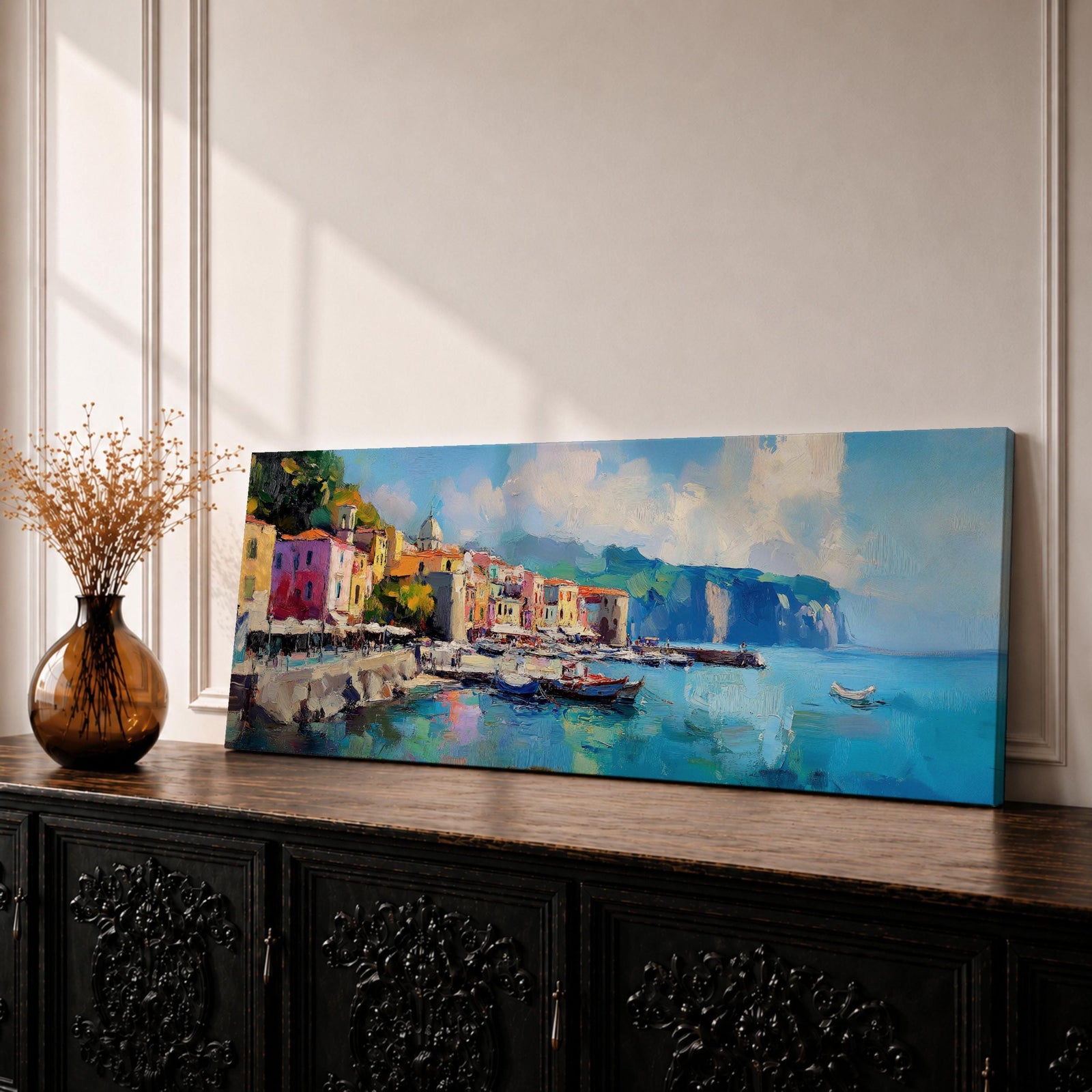 Panoramic Mediterranean harbor village painting featuring colorful seaside houses along a stone waterfront with small fishing boats resting in calm blue water. Soft clouds drift above distant cliffs and green hills while textured brushstrokes capture reflections and gentle movement across the wide coastal scene.