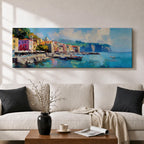 Panoramic Mediterranean harbor village painting featuring colorful seaside houses along a stone waterfront with small fishing boats resting in calm blue water. Soft clouds drift above distant cliffs and green hills while textured brushstrokes capture reflections and gentle movement across the wide coastal scene.