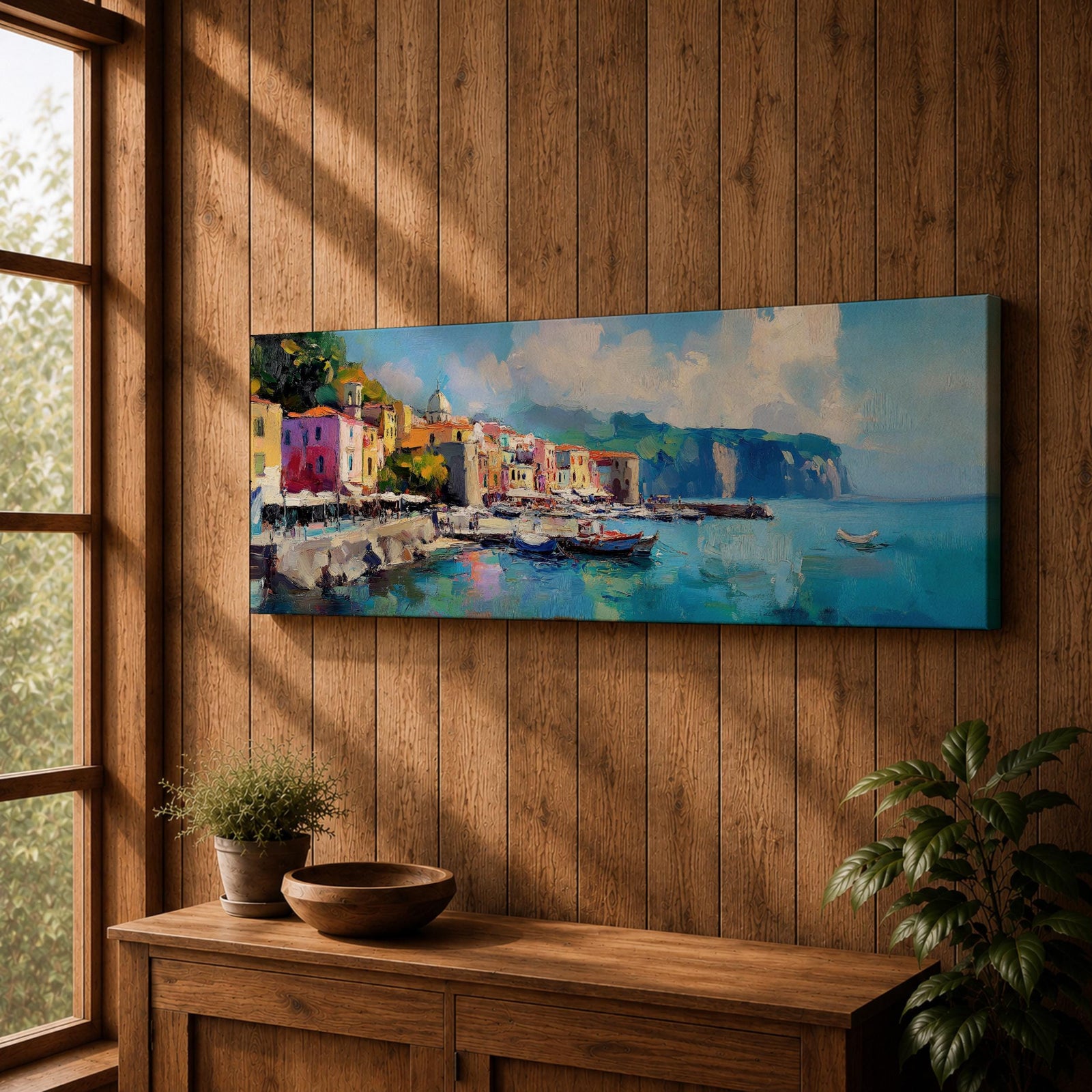 Panoramic Mediterranean harbor village painting featuring colorful seaside houses along a stone waterfront with small fishing boats resting in calm blue water. Soft clouds drift above distant cliffs and green hills while textured brushstrokes capture reflections and gentle movement across the wide coastal scene.
