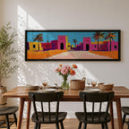 Panoramic desert village painting showing colorful Moroccan kasbah buildings in bright pink and warm ochre tones with tall palm trees lining a sandy road. Bold textured brushstrokes and vibrant colors create a lively North African scene beneath a clear blue sky across the wide horizontal composition.