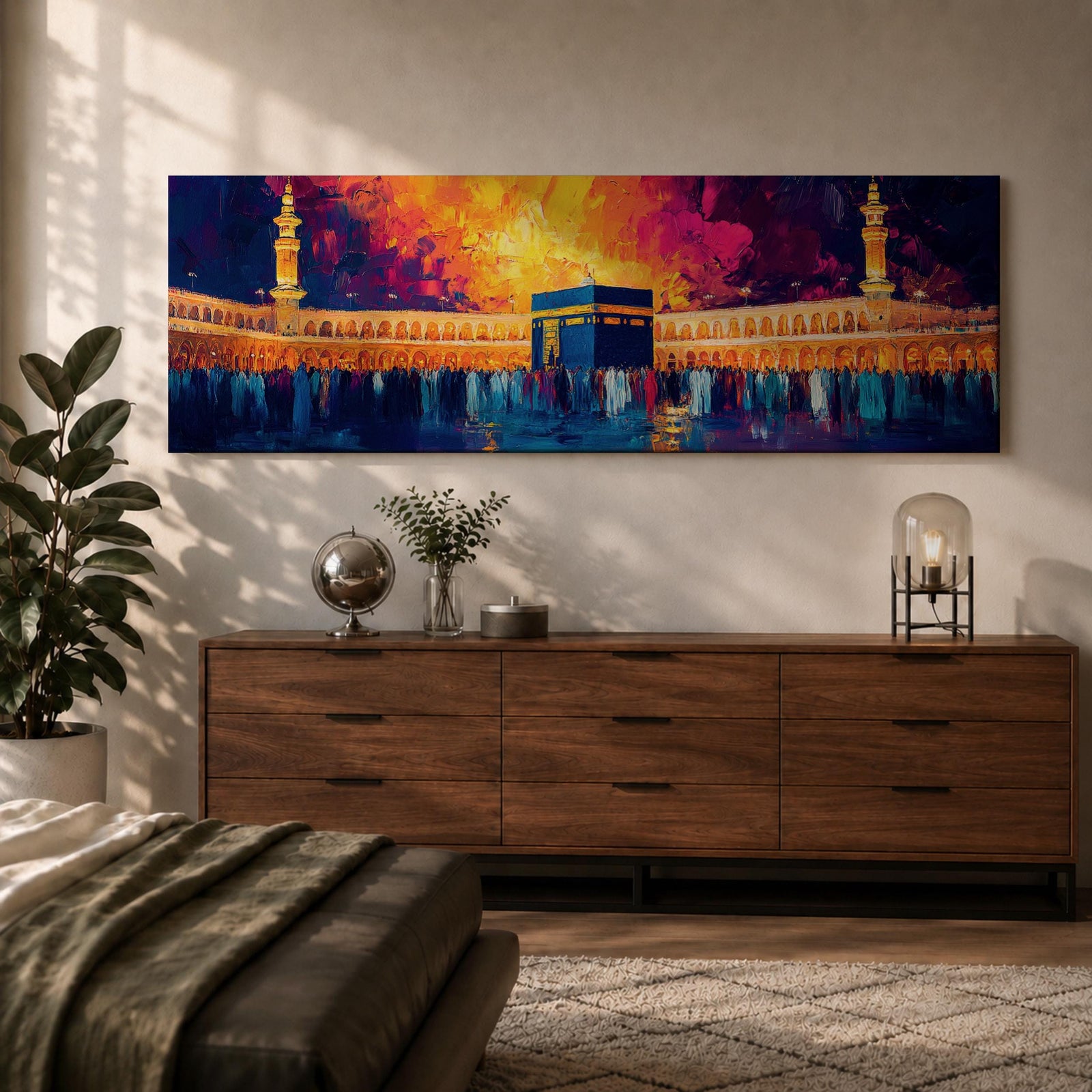 Panoramic painting of the Kaaba at Masjid Al Haram in Mecca surrounded by worshippers within the illuminated mosque courtyard. Tall minarets rise on either side while glowing sunset colors of gold, magenta, and deep blue fill the sky above the sacred Islamic landmark across the wide horizontal composition.