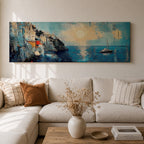 Panoramic Mediterranean coastal painting showing white cliffside houses overlooking deep blue sea at sunset. A sailboat drifts across calm water while sunlight reflects across the horizon and textured brushstrokes form dramatic rocky cliffs and coastal architecture in the wide horizontal seaside composition.