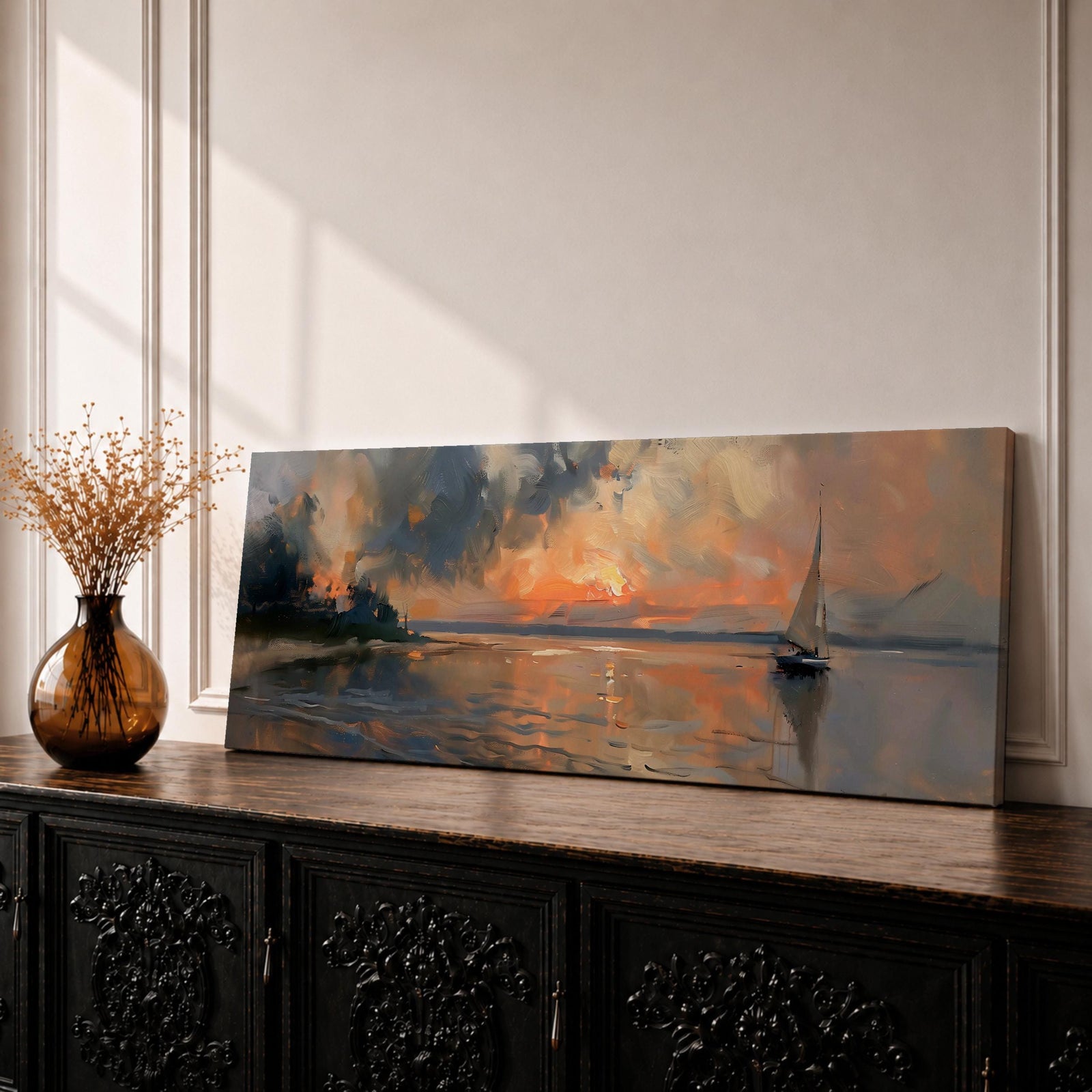 Panoramic seascape painting of a sailboat gliding across calm water at sunset with glowing orange light reflecting across the surface. Dramatic clouds fill the sky while distant shoreline silhouettes and soft reflections create a tranquil coastal scene in a wide horizontal composition.