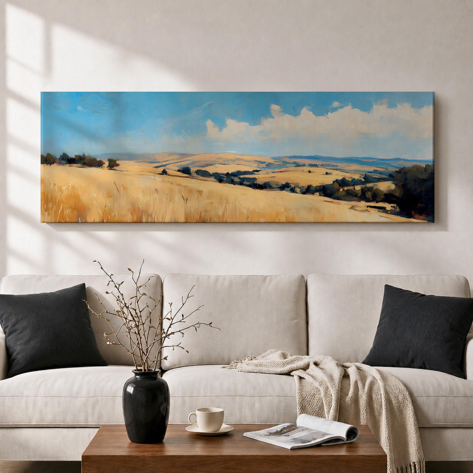 Panoramic wheat field landscape painting showing rolling golden farmland stretching across hills beneath a bright blue sky with scattered clouds. Textured brushstrokes depict tall wheat grasses in the foreground leading toward layered countryside fields, tree clusters, and distant hills across the wide rural horizon.