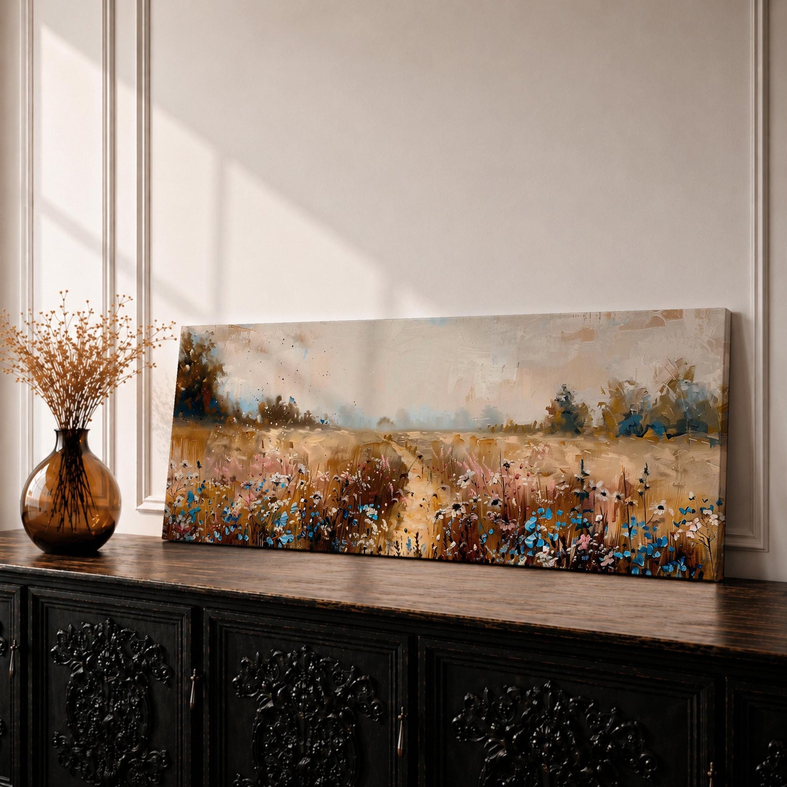 Panoramic wildflower meadow landscape painting featuring a soft rural field filled with scattered blue and white flowers across golden grasses. A narrow path leads through the meadow toward distant trees and open countryside beneath a muted cloudy sky, with textured brushstrokes creating depth across the wide pastoral scene.