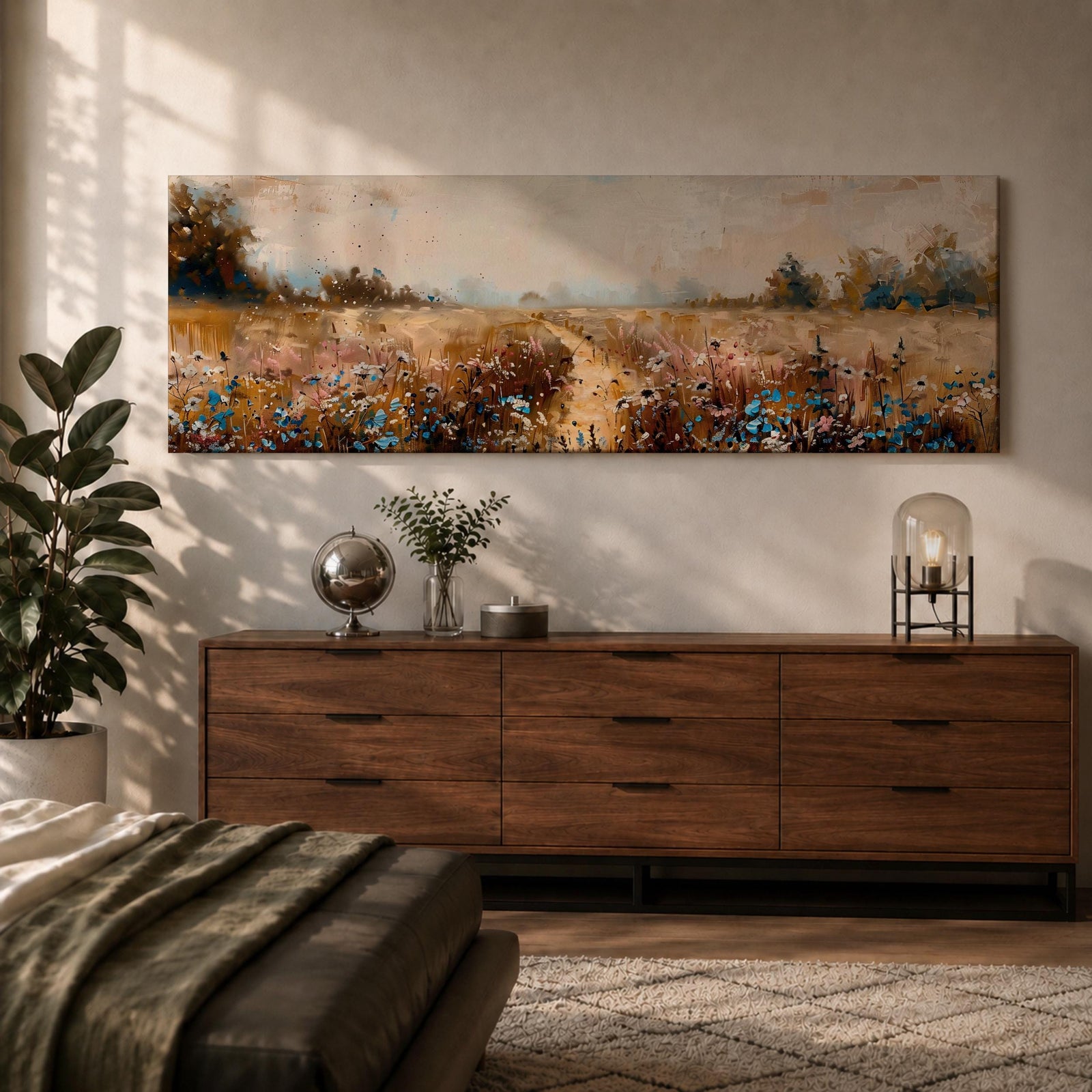 Panoramic wildflower meadow landscape painting featuring a soft rural field filled with scattered blue and white flowers across golden grasses. A narrow path leads through the meadow toward distant trees and open countryside beneath a muted cloudy sky, with textured brushstrokes creating depth across the wide pastoral scene.