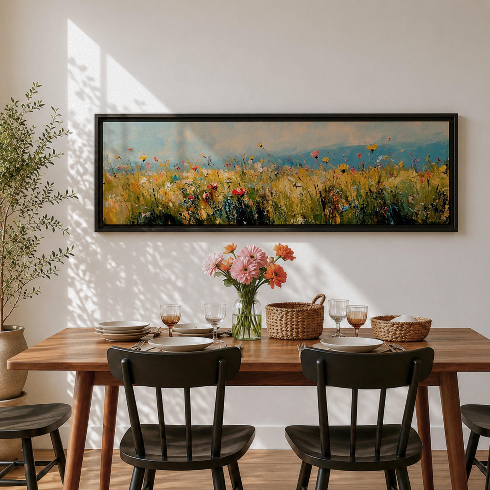 Panoramic wildflower meadow painting featuring tall golden grasses mixed with scattered red, yellow, and blue flowers swaying across an open field. Loose textured brushstrokes create depth through the meadow while a soft blue sky and distant horizon stretch across the wide landscape composition.