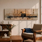 Panoramic painting of the Kaaba at Masjid Al Haram in Mecca surrounded by mosque arches and tall minarets. The sacred black cube stands at the center of a wide courtyard with crowds gathered around while warm golden tones and architectural details stretch across the expansive skyline.