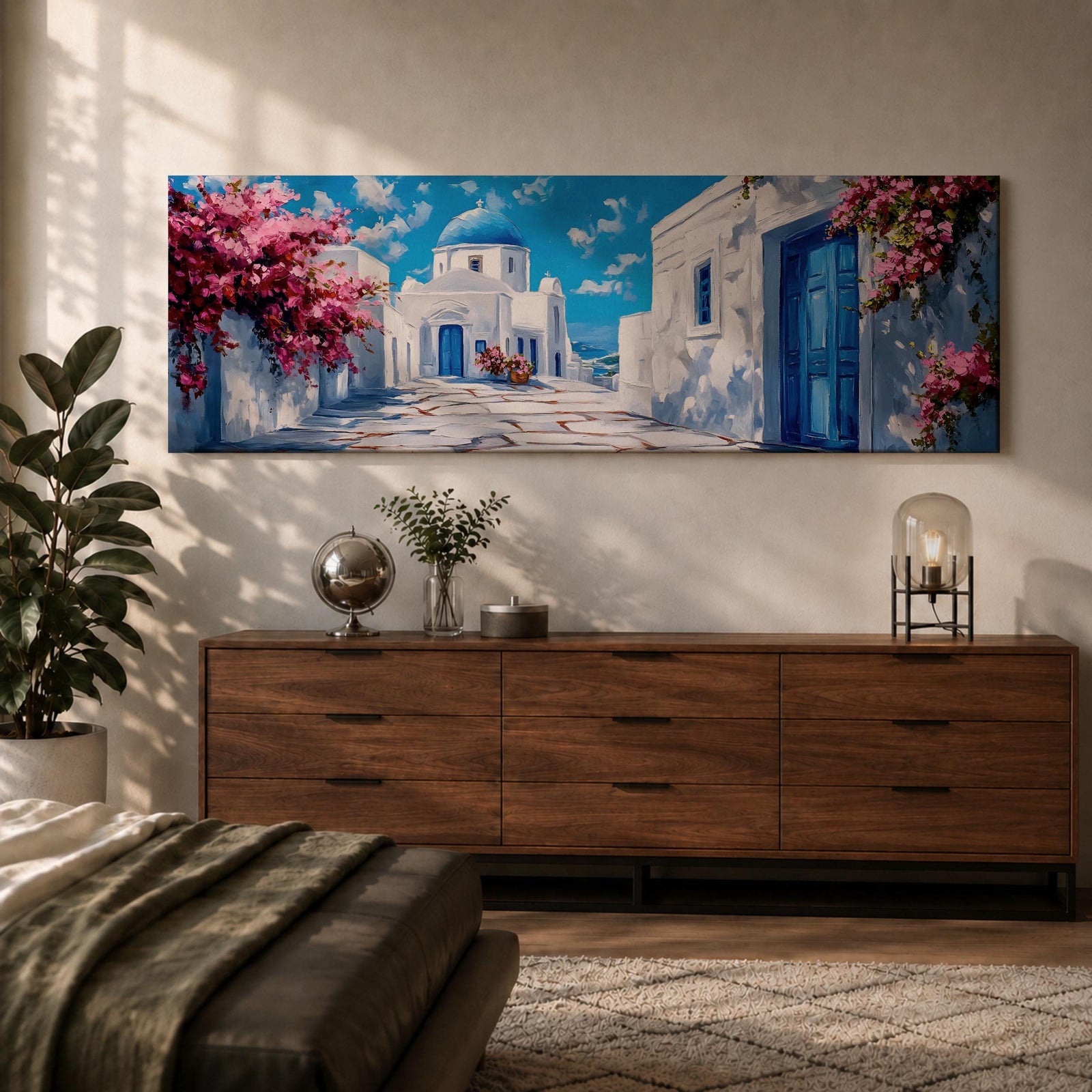 Panoramic painting of a Santorini village featuring whitewashed buildings with blue doors and a domed church along a sunlit stone pathway. Pink bougainvillea flowers frame the scene while bright blue sky and distant Aegean Sea appear beyond the island architecture across the wide composition.