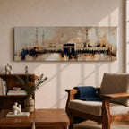 Panoramic painting of the Kaaba at Masjid al Haram with surrounding mosque arches and minarets, rendered in a loose abstract style with warm beige, brown, and black tones. The composition stretches horizontally with expressive brush textures, architectural silhouettes, and layered strokes highlighting the Kaaba at the center of the sacred mosque complex.