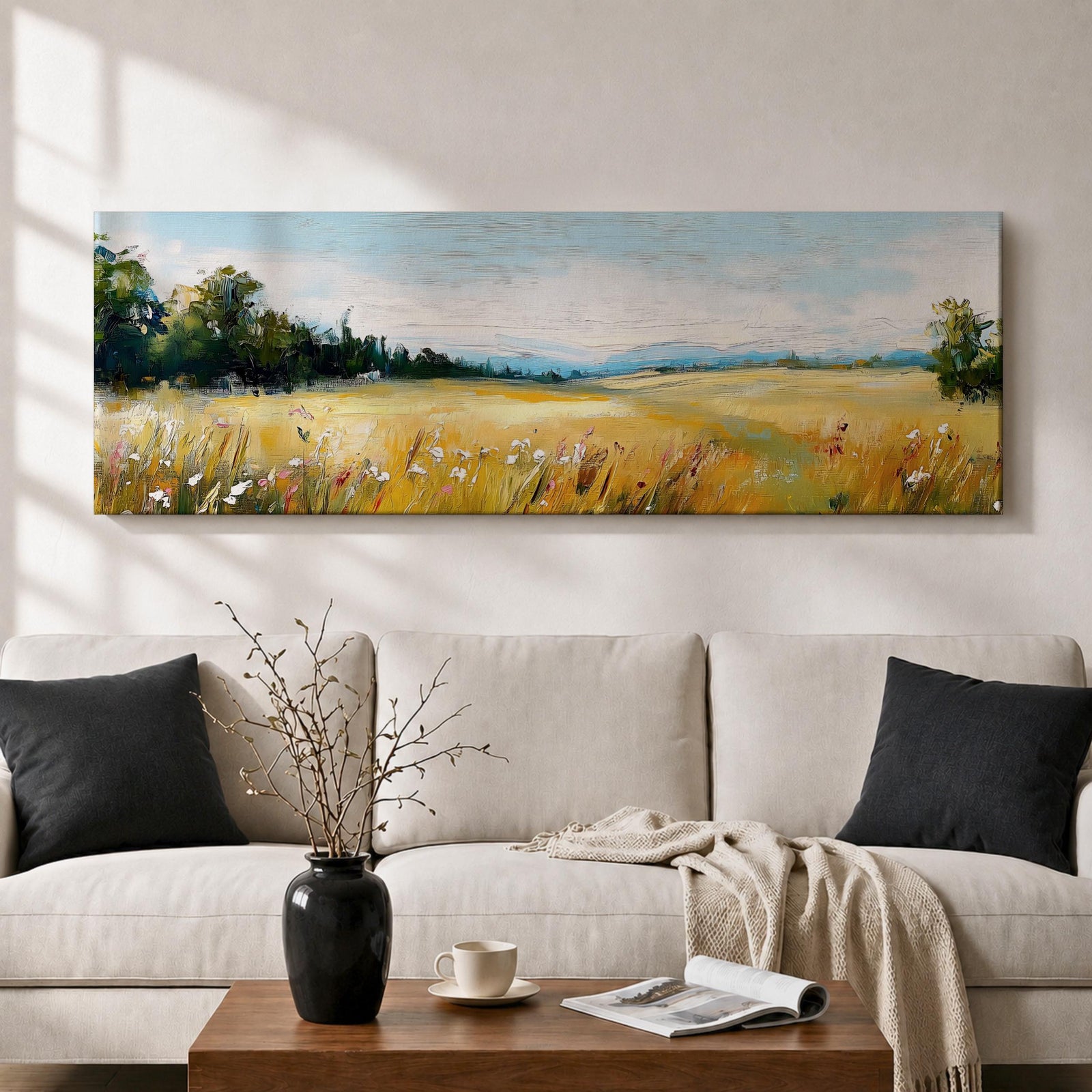 Panoramic countryside landscape painting showing a wide golden field filled with tall grasses and scattered wildflowers. A tree line borders the meadow while distant hills stretch across the horizon beneath a soft blue sky with light clouds across the expansive rural scene.