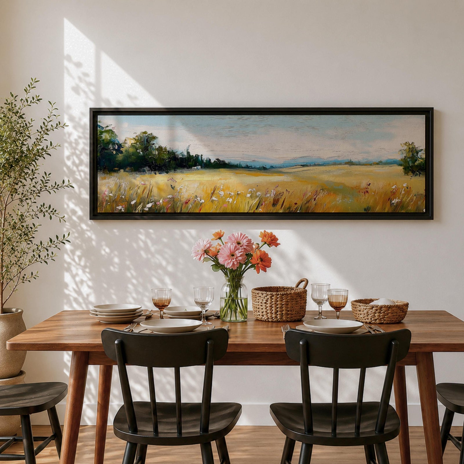 Panoramic countryside landscape painting showing a wide golden field filled with tall grasses and scattered wildflowers. A tree line borders the meadow while distant hills stretch across the horizon beneath a soft blue sky with light clouds across the expansive rural scene.