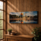 Panoramic canvas artwork depicting the Dome of the Rock in Jerusalem with its iconic golden dome and blue tiled octagonal structure rising above surrounding trees and historic buildings, reflected in calm water in the foreground beneath a bright sky filled with scattered clouds, rendered in a detailed landscape style emphasizing the architecture and skyline of the sacred site.