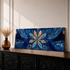 Panoramic floral mandala artwork featuring a symmetrical lotus flower design with layered petals spreading outward in deep blue and gold tones, accented with delicate botanical shapes and watercolor textures that create an intricate ornamental pattern across a wide horizontal composition.