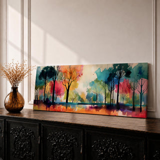 Panoramic abstract watercolor painting of a forest landscape with tall slender tree silhouettes reflected in still water, surrounded by vibrant washes of teal, orange, red, yellow, and green forming a colorful woodland scene with expressive brushwork and soft atmospheric blending.