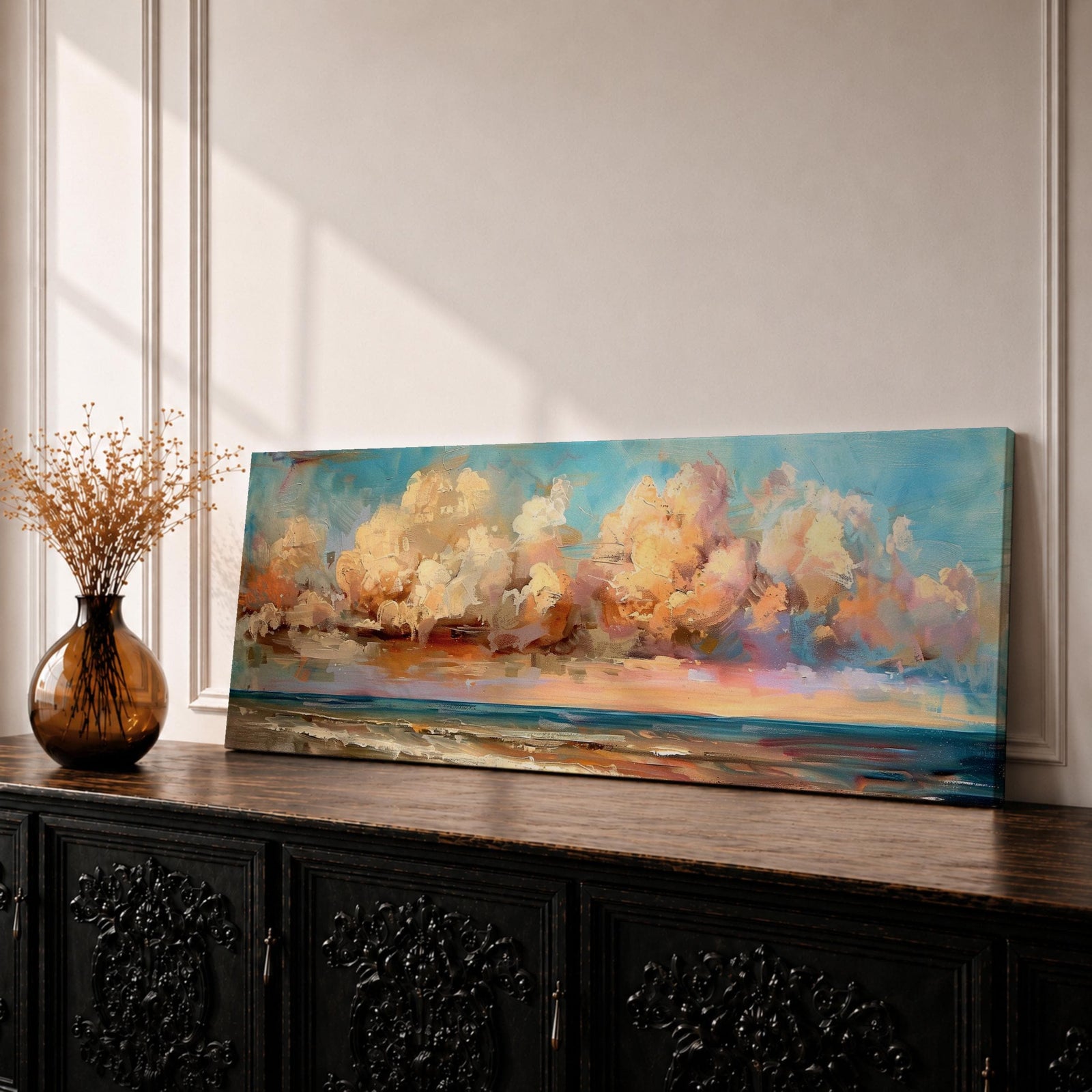 Panoramic coastal painting featuring dramatic sunset clouds above the ocean horizon with waves along a sandy beach, rendered in warm pastel sky tones and textured brushstrokes creating a peaceful seaside landscape.