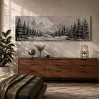 Panoramic monochrome landscape artwork depicting snow covered mountains and a dense pine forest with a winter valley scene rendered in black and white tones.
