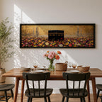 A panoramic painting of the Kaaba standing at the center of a vibrant field of colorful flowers with red, pink, yellow, and white blossoms stretching across the foreground, set against a glowing gold textured background with faint mosque silhouettes and minarets surrounding the sacred structure.