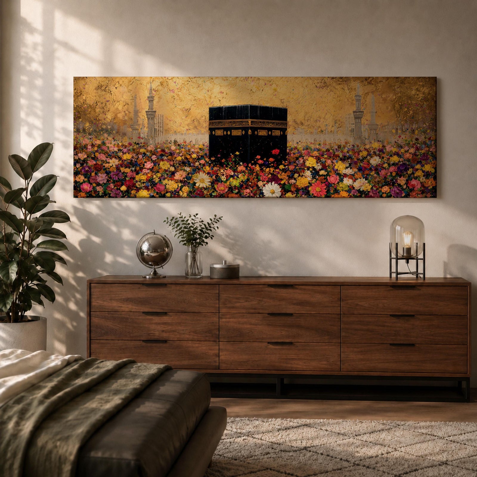 A panoramic painting of the Kaaba standing at the center of a vibrant field of colorful flowers with red, pink, yellow, and white blossoms stretching across the foreground, set against a glowing gold textured background with faint mosque silhouettes and minarets surrounding the sacred structure.